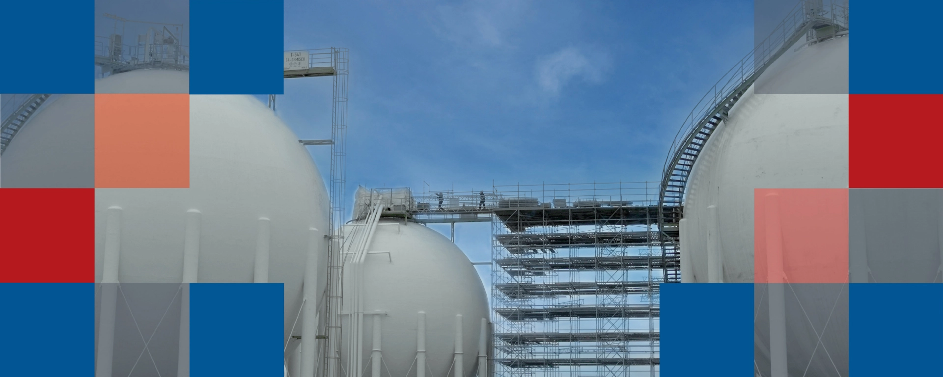 An industrial site with round silos and scaffolds