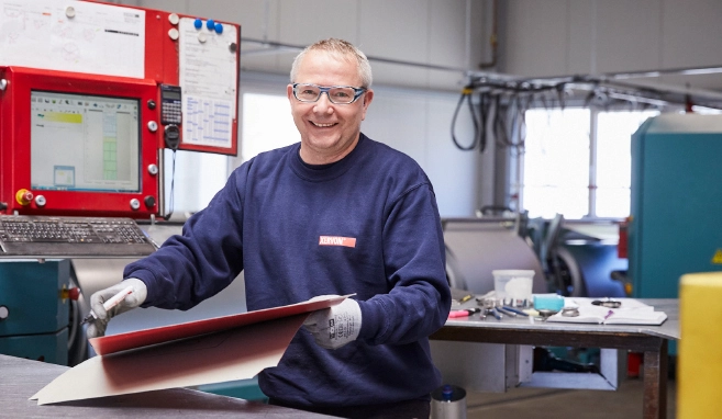 An insulation specialist working with an insulation panel stamping machine