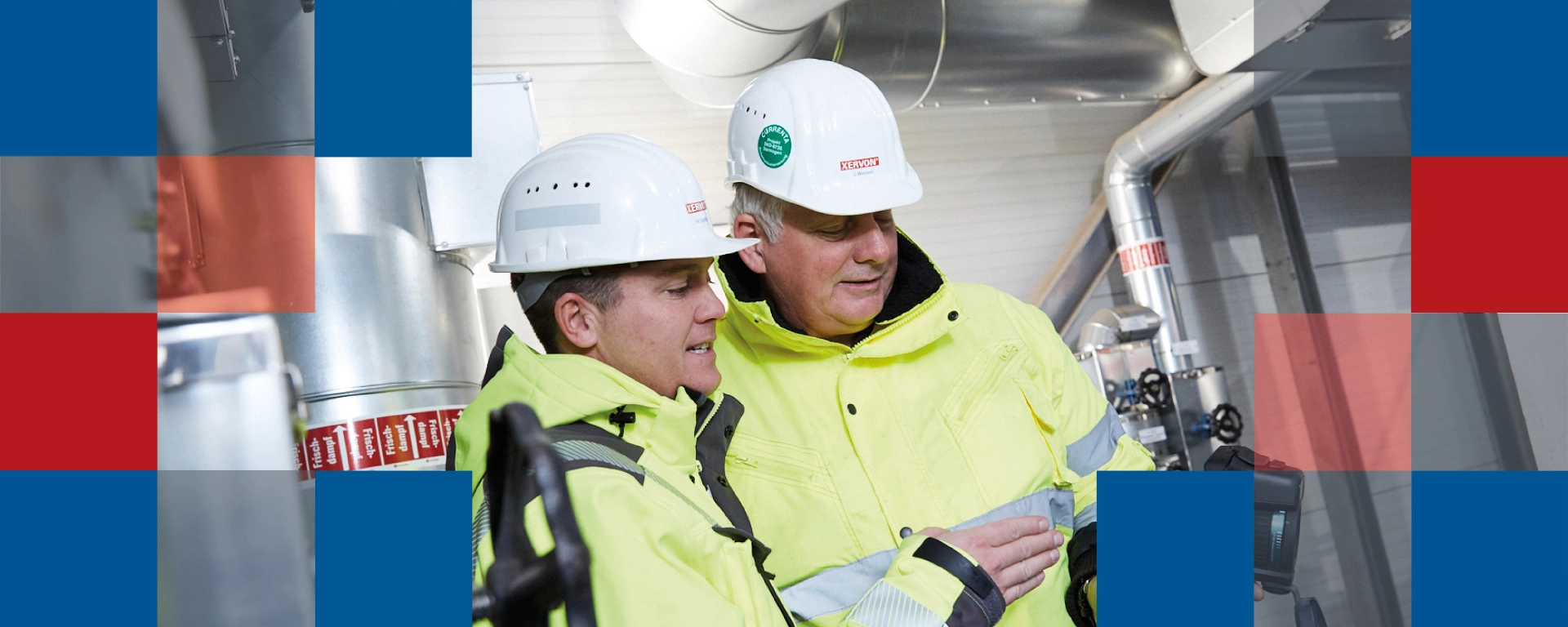 Two men wearing personal protective equipment working with a thermal imaging camera at an industrial plant